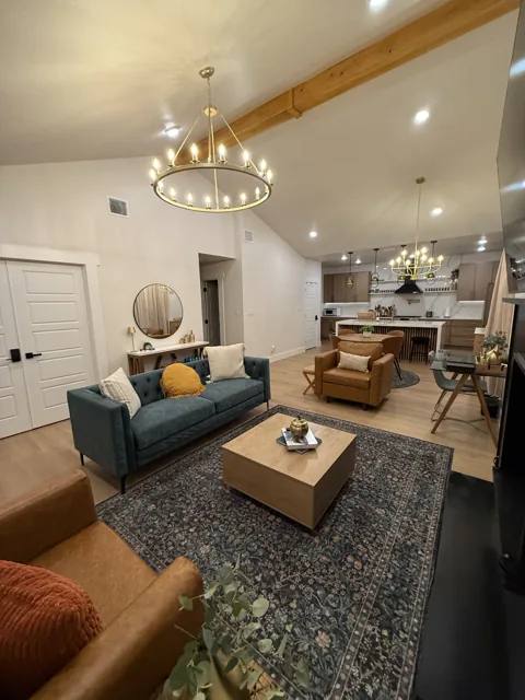 Shared living room with blue sofa, armchairs, and gold lighting