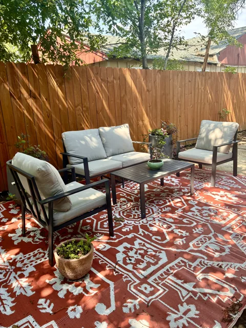 Outdoor chairs and sofa under the trees