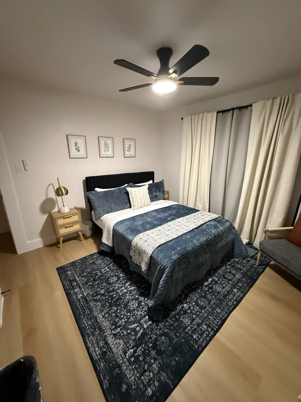 Short-stay bedroom with blue bedding and a comfortable chair